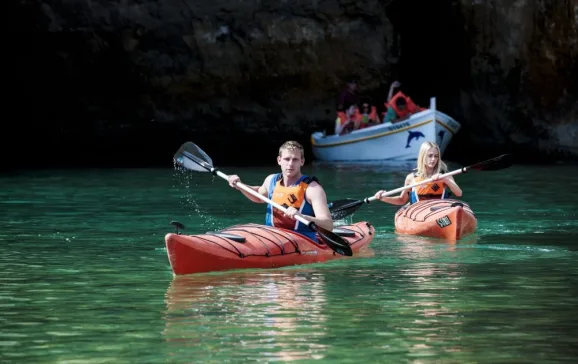 couple canoeing by cave