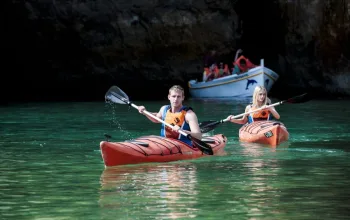 couple canoeing by cave