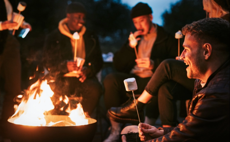 Friends enjoying marshmallow together by the bonfire