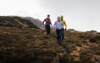 Group running down hill with waterproof gear on   Lake District ELSEY WHYMAN DAVIS CREDIT 