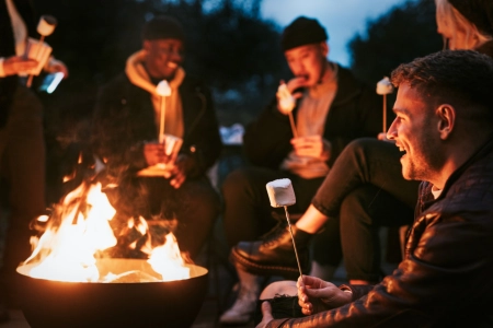 Friends enjoying marshmallow together by the bonfire
