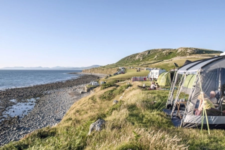 tents pitched on hillside next to beach with pebbles campsites in snowdonia credit cae du farm holidays campsite