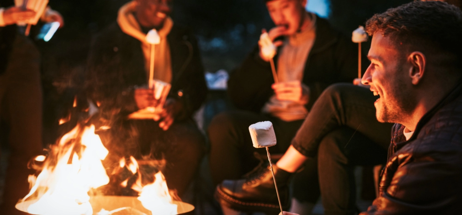 Friends enjoying marshmallow together by the bonfire
