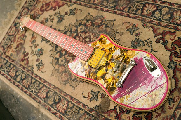 The body of this rad looking guitar is an old skateboard.