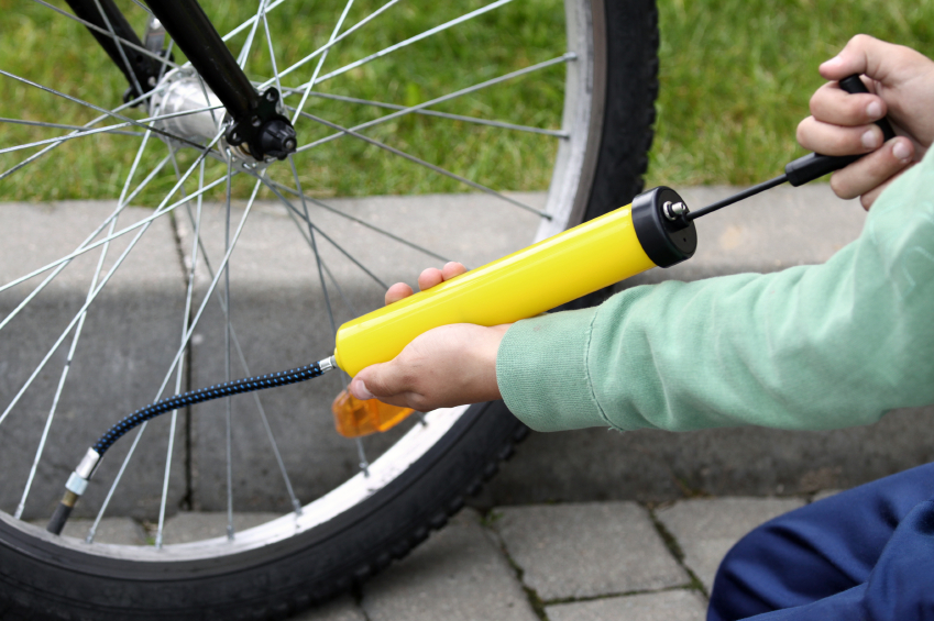 Boy pumping his bicycle tyre, close-up on hands