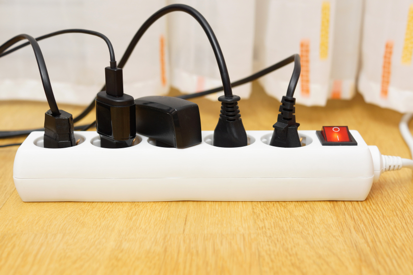 many electrical appliances pluged in surge protector. Power cons
