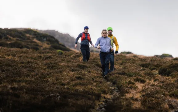 Group running down hill with waterproof gear on Lake District ELSEY WHYMAN DAVIS CREDIT