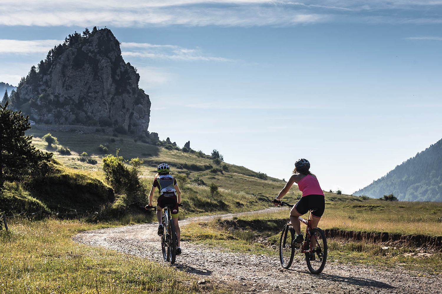 Women cycling with mountains in background, Catalonia