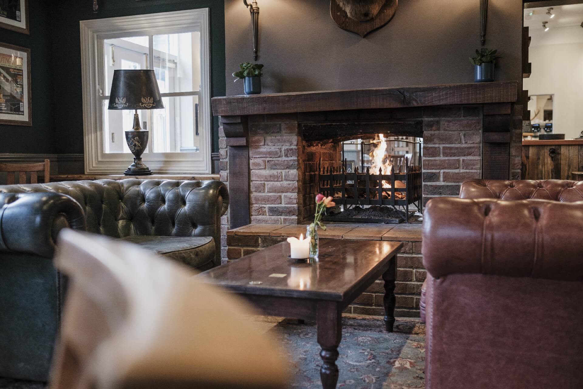 Cosy communal area with leather sofas and open fire, New Forest