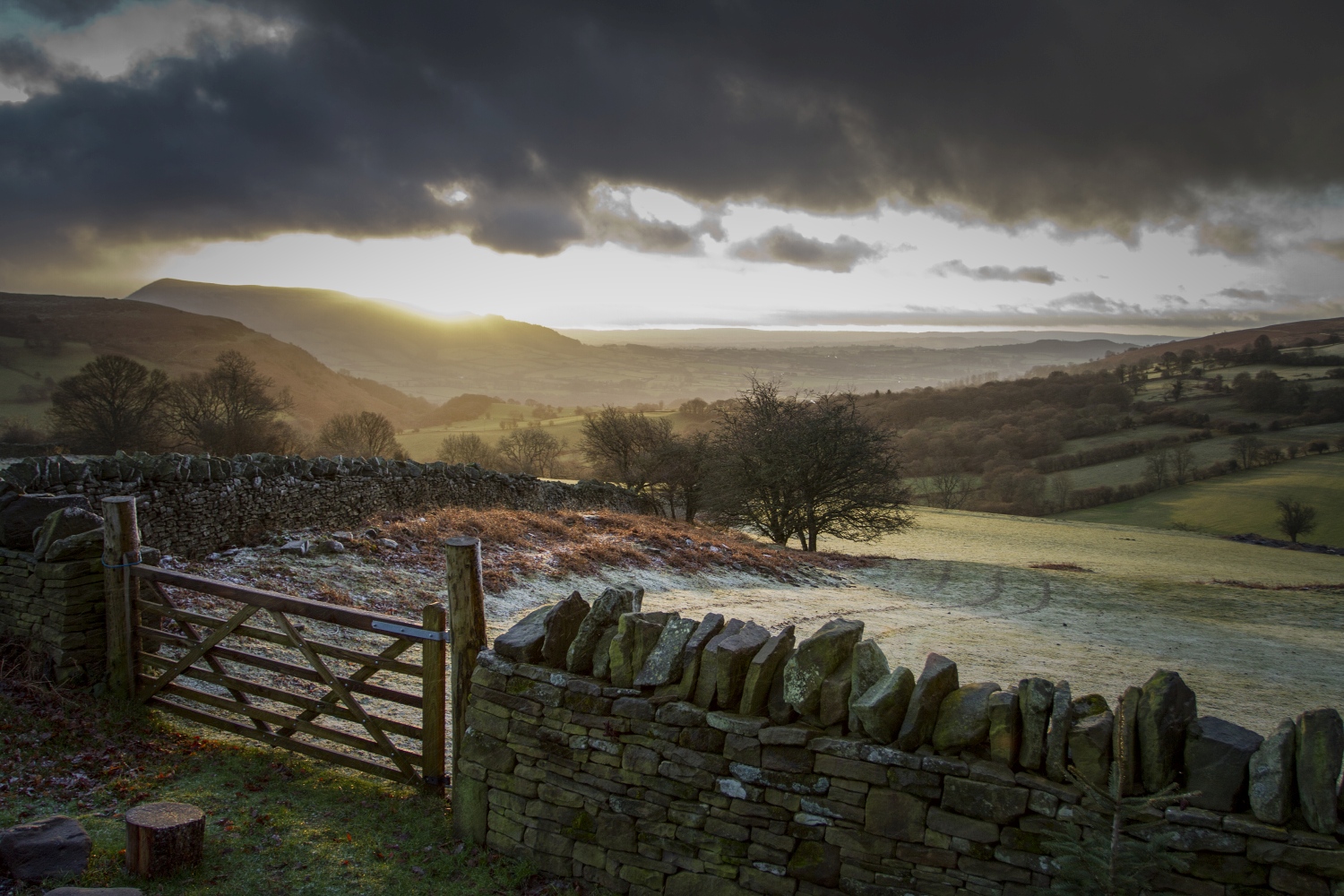 View over gate and wall across grassy valley with frost - Sugarloaf Mountain Walk