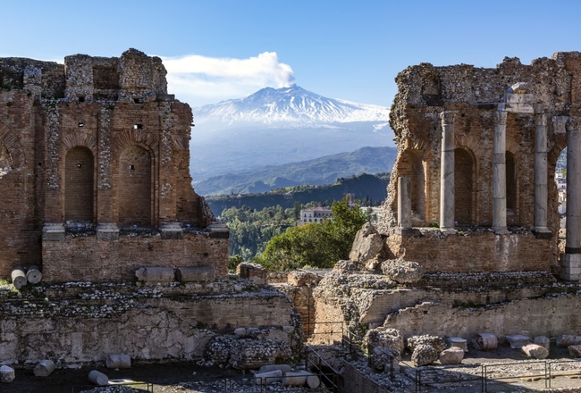 Etna in Sicily seen through ruins of ancient amphitheater in Taormina.jpg